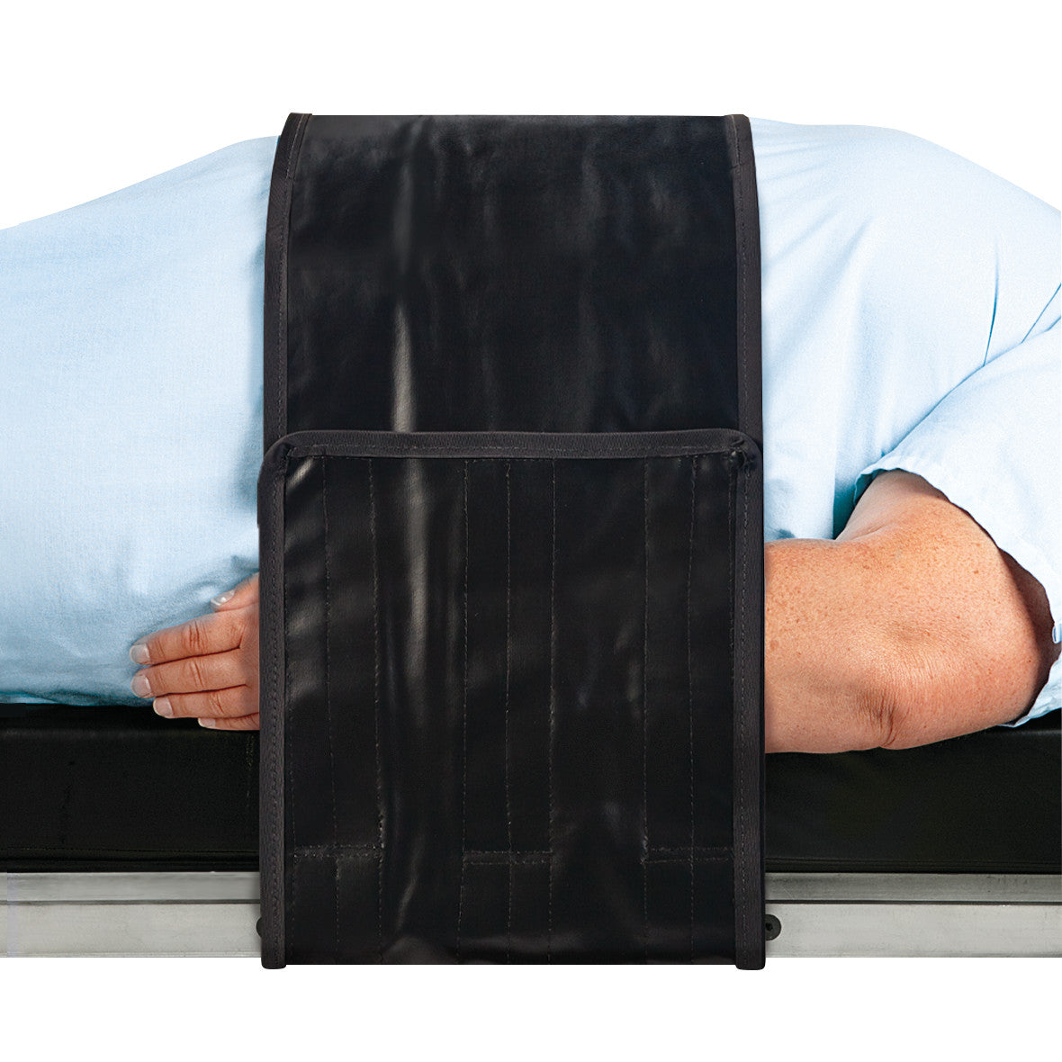 A person lies on their side with an AliMed Nonmetallic Operating Room Table Strap securing them in place on the table.