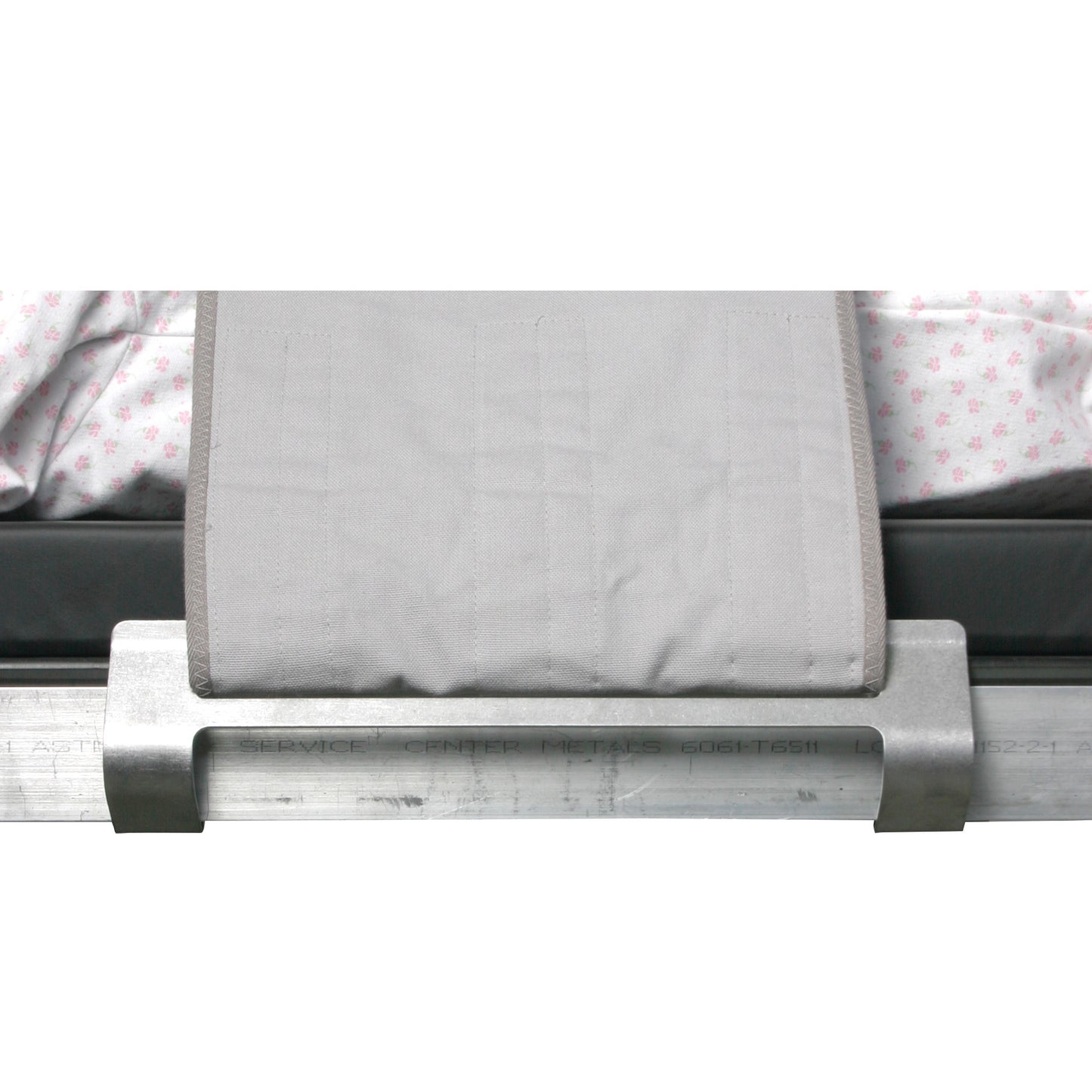 AliMed Grabber Bracket secures a light gray strap onto a hospital bed with floral-patterned sheets on a mattress base.