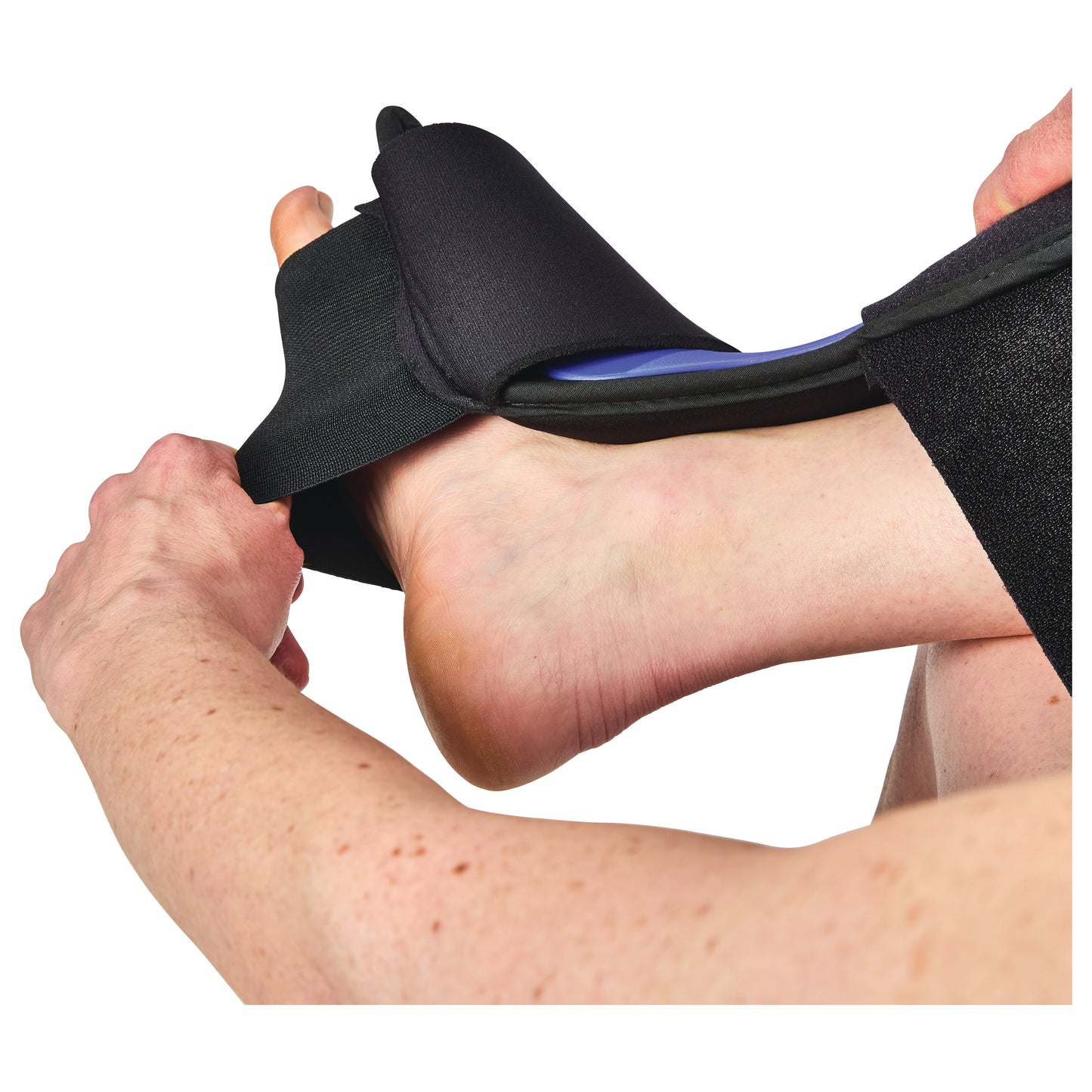 Person adjusting an AliMed FREEDOM Dorsal PF Night Splint on their foot, with hands pulling straps for a secure fit.